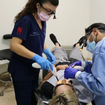 Dentist and his assitant during treating a patient